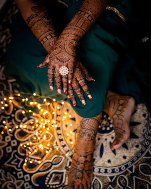 An artistic shot showing a bride's hands and feet adorned with mehandi. This demonstrates the full bridal package, ensuring the designs complement each other perfectly.