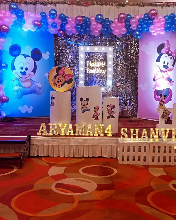 A full view of our Mickey and Minnie Mouse birthday stage setup. We combine printed backdrops, a shimmering sequin wall, and custom light-up names to create a focal point for the celebration.
