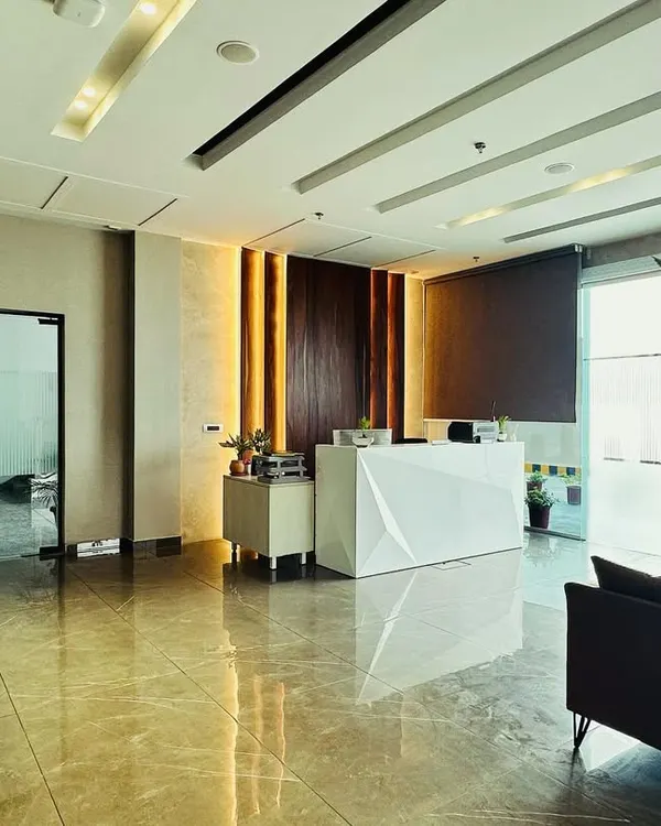 A wide-angle view of the M/s ALP office lobby, showcasing the spacious layout that ensures a smooth flow of traffic. The design connects the reception desk, waiting area, and entry to the main office seamlessly.