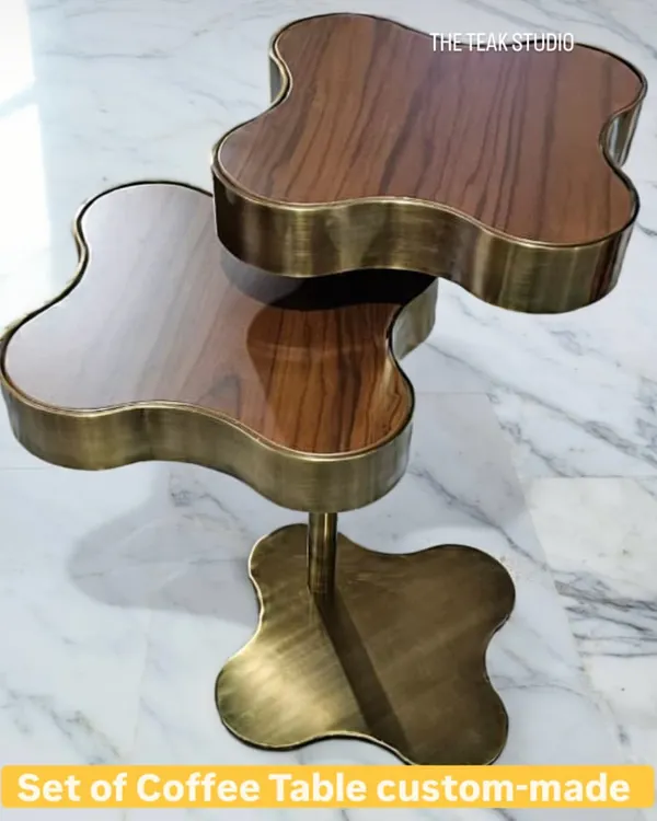 This custom-made set of coffee tables features a unique clover-like shape. The combination of a stainless steel structure in an antique brass finish and a walnut PU top creates a luxurious and eye-catching centerpiece.