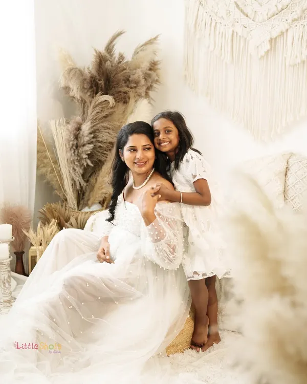 A serene and beautiful moment between a mother and her daughter. This boho-themed maternity shoot uses soft, natural textures and lighting to create a peaceful and loving atmosphere.