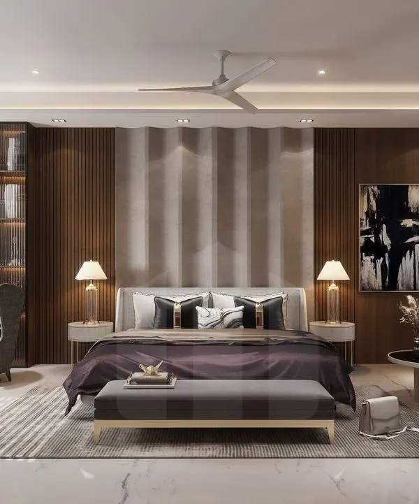 This luxurious master bedroom suite is a complete private retreat. It features a dedicated seating area with wingback chairs, a built-in library, a comfortable sleeping zone, and a separate sofa lounge, all tied together with rich wood tones and sophisticated decor.