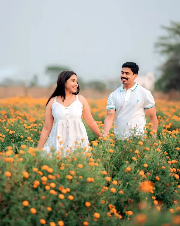 Walking hand-in-hand through a field of marigolds. For this nature-filled pre-wedding shoot, the goal was to create a feeling of pure, simple joy. The warm colors and the couple's easy smiles make this a perfect example of a romantic outdoor session.