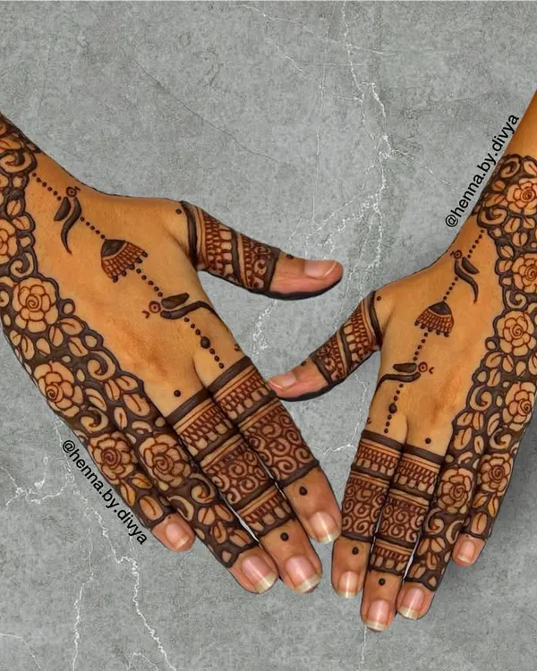 This design features a beautiful floral cuff and delicate hanging jhumka motifs. The pattern is a classic choice for wedding guests, offering a touch of tradition and elegance.