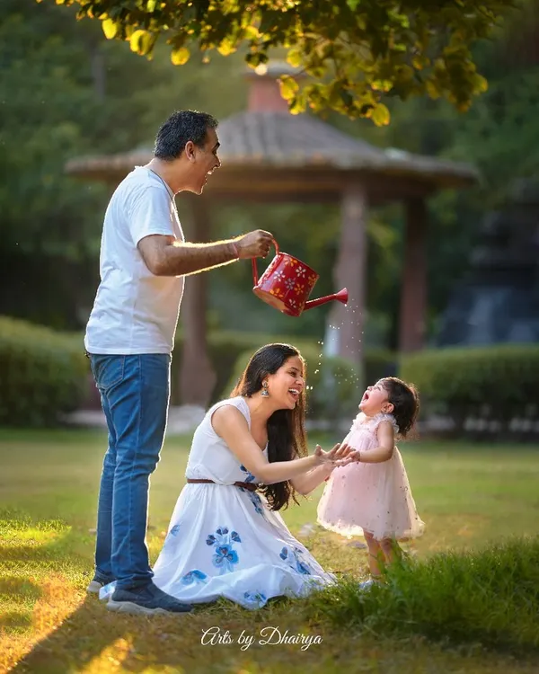 The best family photos come from genuine moments of fun. I love creating playful scenarios like this one, where a little splash from a watering can leads to the most authentic laughter and joy.