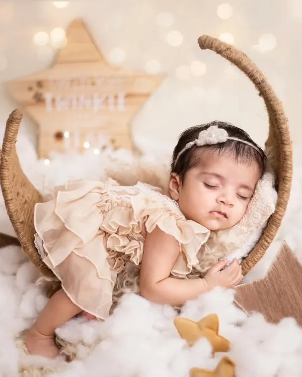 I love you to the moon and back. This dreamy newborn portrait features a sweet baby girl sleeping on a moon prop. I use soft fabrics and a starry background to create a magical and safe environment for your newborn.