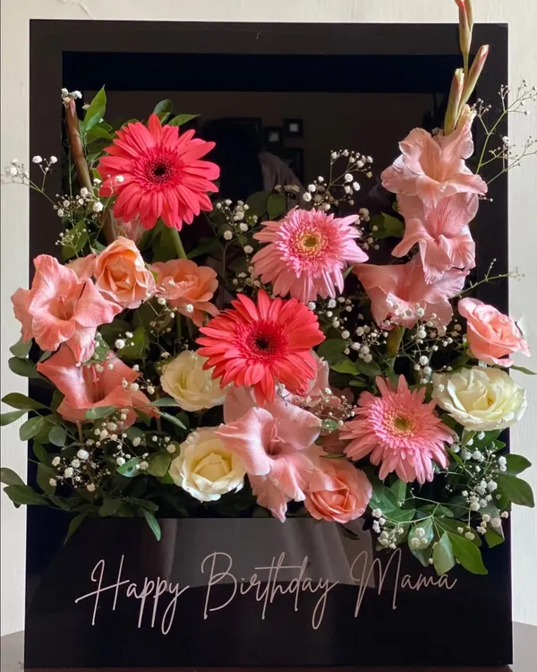 This luxurious acrylic floral box is a showstopper. I arrange fresh gerberas, roses, and baby's breath in a sleek black box and add a custom "Happy Birthday Mama" message for a truly personal and modern floral gift.