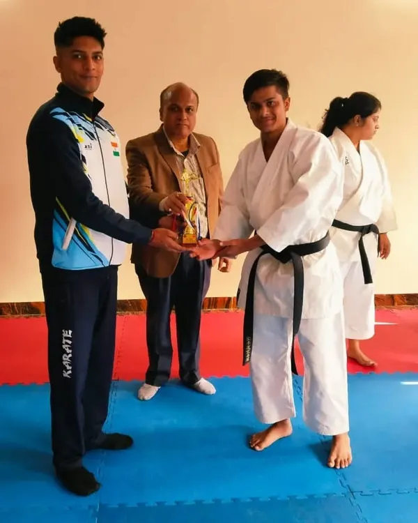 Presenting an award to a student who achieved his black belt. This is a significant milestone in any martial artist's journey.