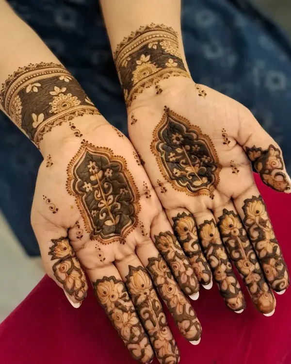 An elegant and modern henna design perfect for a wedding guest or festive occasion. This style features delicate floral work on the fingers and a beautiful architectural motif on the palm, leaving negative space for a contemporary feel.