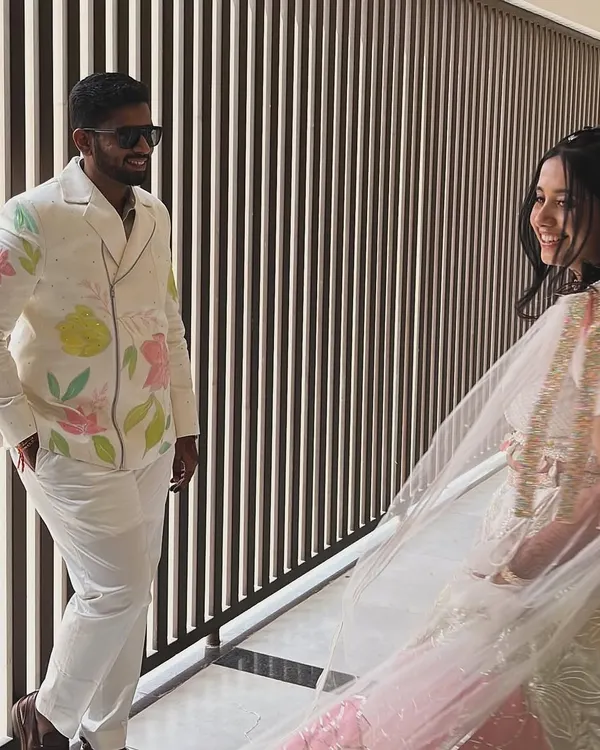 A beautiful moment captured between the bride and groom. I loved creating his custom carnival outfit, with abstract florals that subtly matched her beautiful lehenga, making their look truly unique and personal.