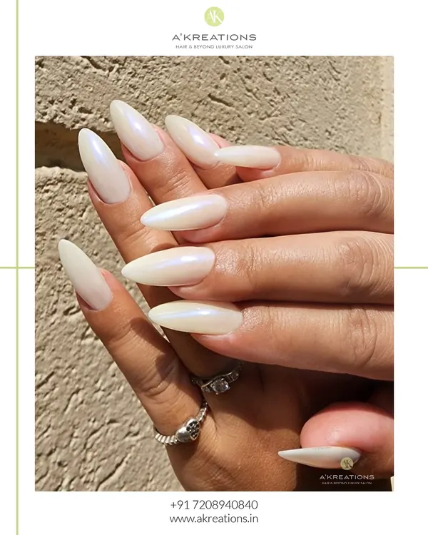 The definition of classic elegance. These long, almond-shaped nail extensions are finished with a pearlescent white polish that gives a beautiful, iridescent sheen in the light.