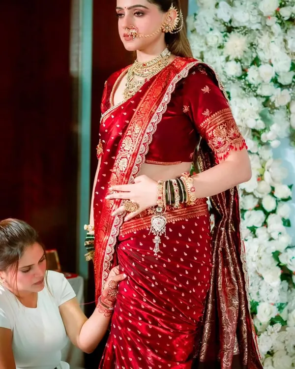 A behind the scenes moment where I am perfecting the pleats of a bride's red wedding saree. Every detail matters for a flawless finish.