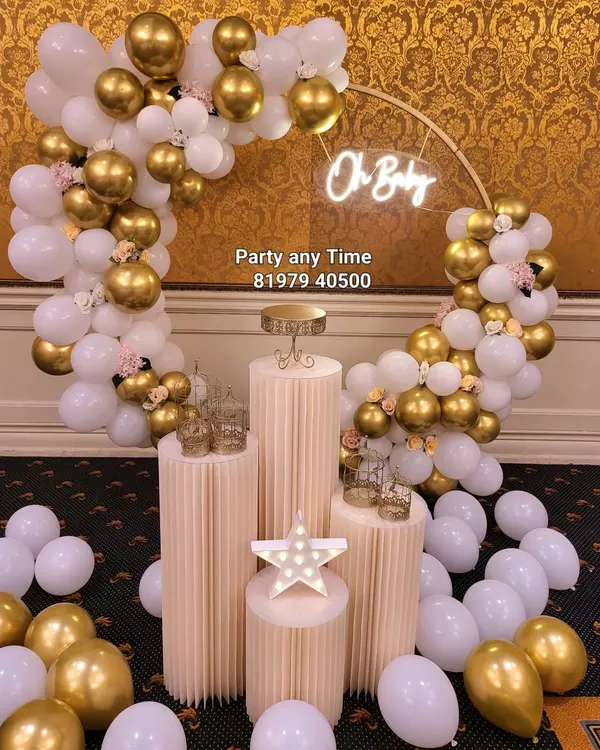 An elegant 'Oh Baby' setup for a baby shower. The white and gold chrome balloons with small flower details create a sophisticated and celebratory look.
