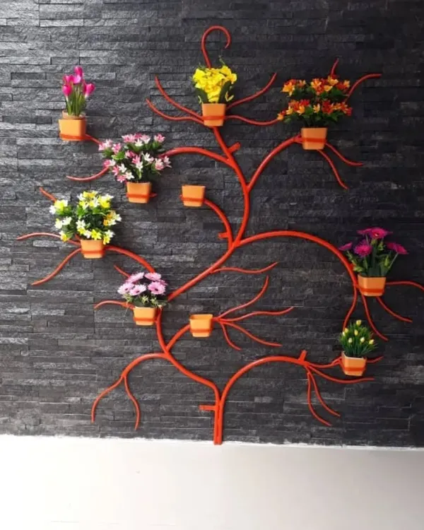 This is a custom wall art piece I created that also serves as a vertical planter. The metal tree-shaped structure is a space-saving solution for plant lovers, allowing you to display multiple small pots in an artistic way.