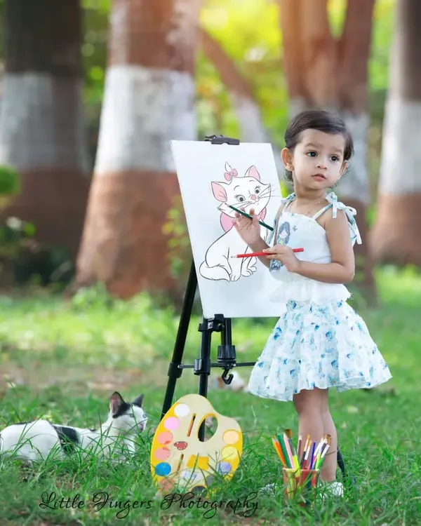 This is what pure, candid joy looks like. I love capturing these unscripted moments, like when a new feline friend decides to join our 'Little Artist' session. It’s these sweet, unexpected interactions that create the most magical childhood portraits.
