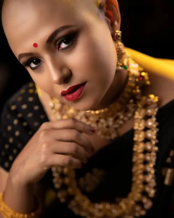 This is from a powerful 'Bald, Bold, Beautiful' concept shoot. I created a dramatic smokey eye and a classic red lip to highlight her striking features and confident gaze. This look is all about empowerment and redefining beauty standards in editorial makeup.
