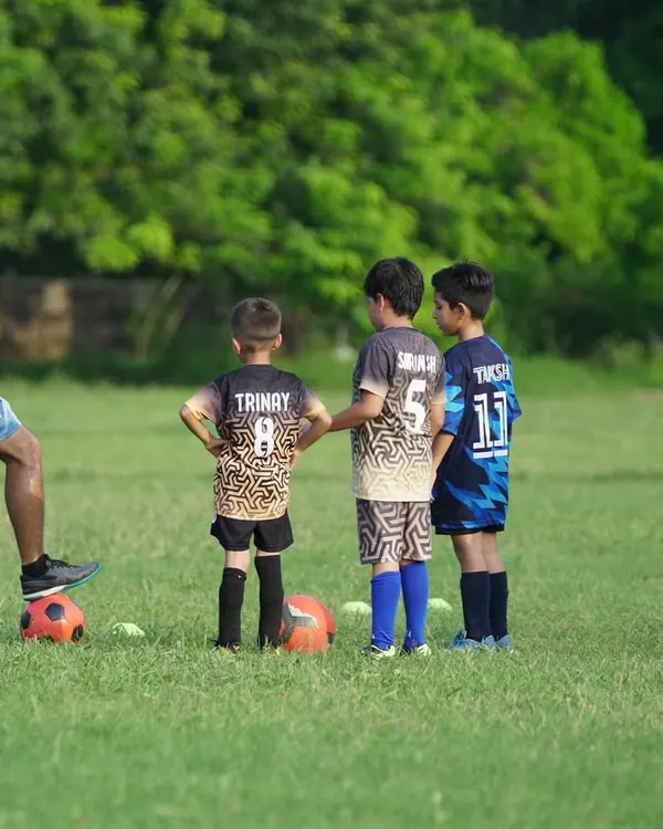 A coach demonstrating a skill to a group of attentive young players. This image captures our hands-on approach to coaching and mentorship.