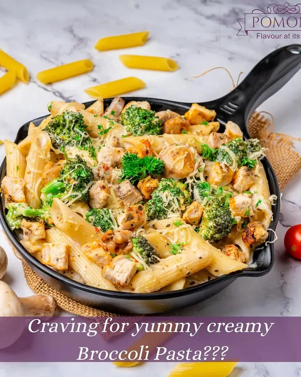 A close-up of my creamy broccoli pasta, prepared in a skillet. This dish combines tender penne, fresh broccoli, and chicken in a rich, flavorful white sauce, a favorite among my customers.