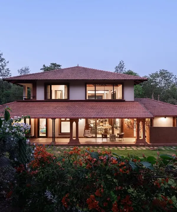 As twilight settles over the Western Ghats, this Coorg retreat glows like a lantern in the forest. Its laterite base is rooted deep in the red earth, while tiled eaves stretch wide like outstretched arms, creating a home that breathes with the land.