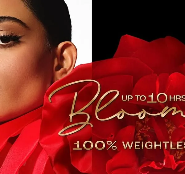 A vibrant commercial advertisement for Lakmé's 'Rouge Bloom' matte lipstick. The shot is a diptych, featuring a model applying the rich red lipstick on the left and a close-up of the product against a floral-inspired background on the right, emphasizing the product's color and weightless feel.
