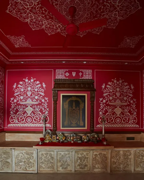 This home temple in Hyderabad is a testament to the power of bold design rooted in tradition. The vibrant red walls, entirely hand-painted by master artists from Jaipur, create a space that is both meditative and awe-inspiring, showcasing how color and craft can evoke deep emotion.
