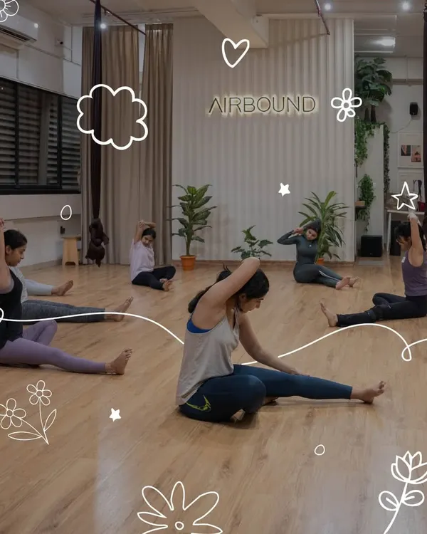 Participants warm up during an aerial silk experience in Mumbai. Our sessions begin with foundational stretches to prepare the body for graceful movement in the air.