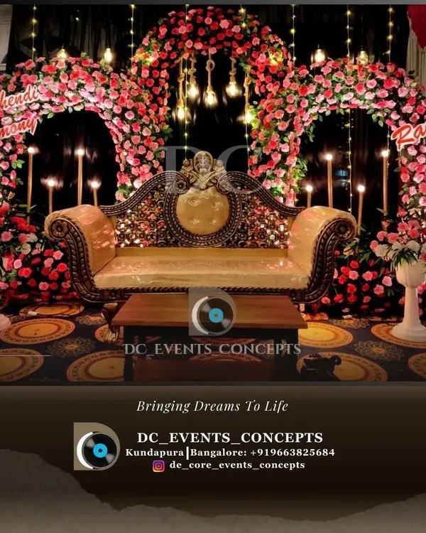 A spectacular Mehendi stage with two large circular arches made of pink roses and lit by hanging bulbs. The ornate gold sofa provides a regal seat for the bride-to-be during her ceremony.