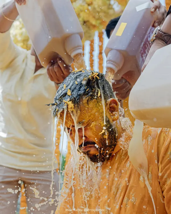 The Haldi ceremony gets wild as the groom is doused with milk and turmeric by his friends at this fun-filled beach wedding in Thailand.
