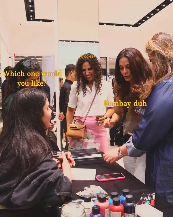 A candid moment from the TUMI event where guests are choosing their favorite city-themed luggage tag design. The "Bombay duh" choice was definitely a popular one among the crowd.