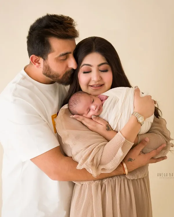A new family of three, wrapped in love. This portrait captures the quiet, tender moments right after a baby's arrival.