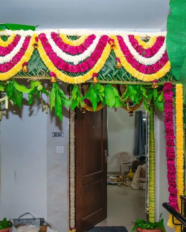 A traditional entrance chapra for a Gruhapravesam. I use real banana trunks, mango leaves, and garlands of marigold and chrysanthemums for an authentic and auspicious welcome.