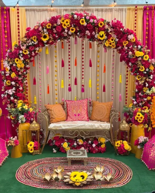 This is our signature Haldi and Mehndi setup. We combine a lush floral arch of marigolds, roses, and sunflowers with vibrant pink and yellow drapes, traditional tassels, and elegant seating to create the perfect festive atmosphere for your pre-wedding functions.