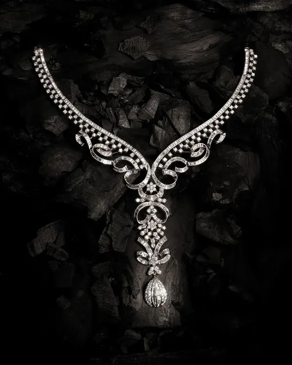 A high-end diamond necklace, intricately detailed and set against a dark, textured background to emphasize its brilliance. This is an example of my luxury jewellery photography, where I use dramatic lighting to capture every facet and sparkle.