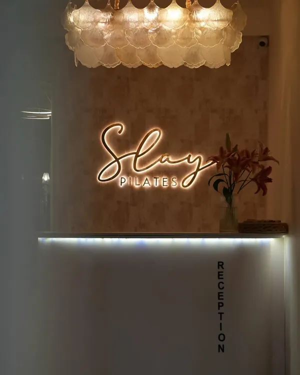 Welcome to Slay Pilates. This is where your transformation begins, from the moment you walk in and see our glowing reception desk.