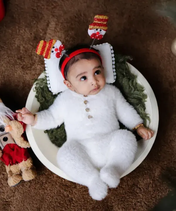 A festive newborn portrait for my son's first Christmas. We used classic holiday props like a Santa figure, candles, and a Christmas tree to create a warm and magical atmosphere for his baby photoshoot.