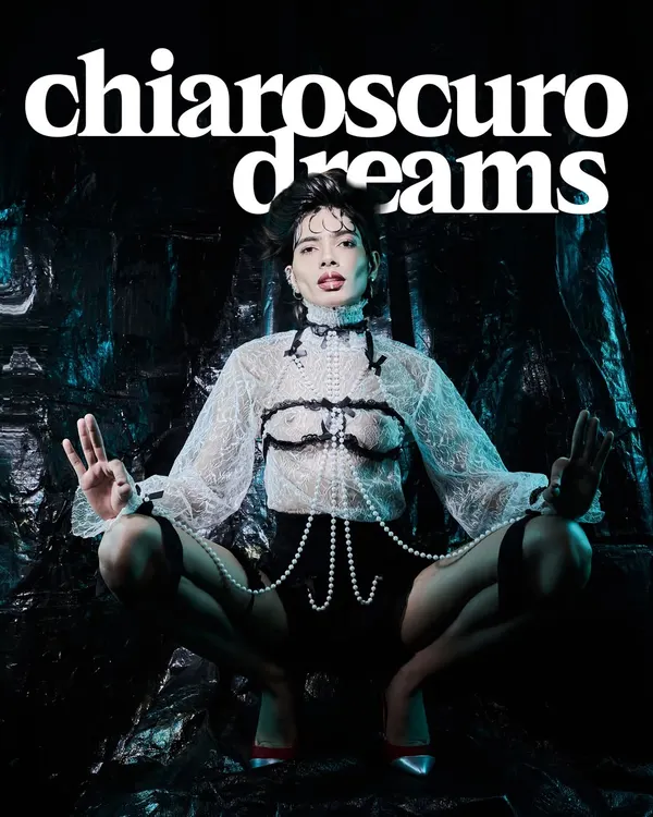 From the 'Chiaroscuro Dreams' editorial, this image plays with the contrast between light and dark. The pearl body jewellery is the centerpiece, highlighted against a sheer lace top to create a look that is both delicate and daring.