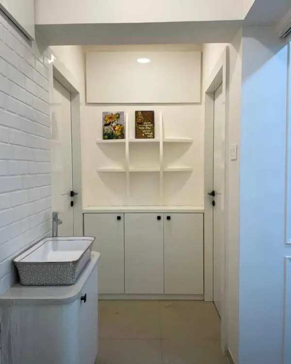 A complete entryway makeover. We transformed this passage by adding a full wall of concealed storage, open display shelves, and a stylish washbasin area, making it incredibly functional without feeling cluttered.