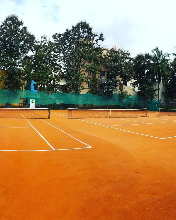 A wide view of our dual clay courts, offering ample space for the practical sessions included in our coach development programs.