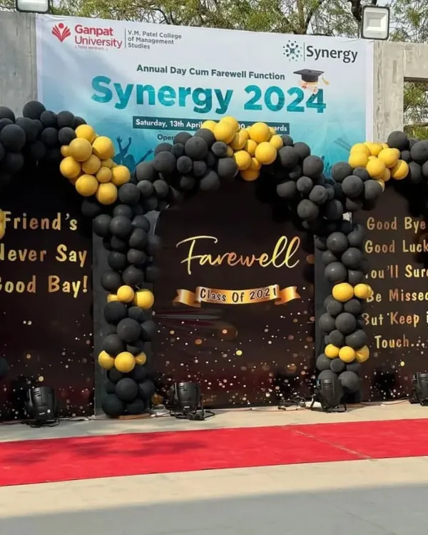 We create impressive setups for major institutional events like this college farewell function. This decor features a large, fully branded backdrop for "Synergy 2024," a dramatic black and gold balloon arch, and a red carpet entrance to provide a premium experience for attendees.