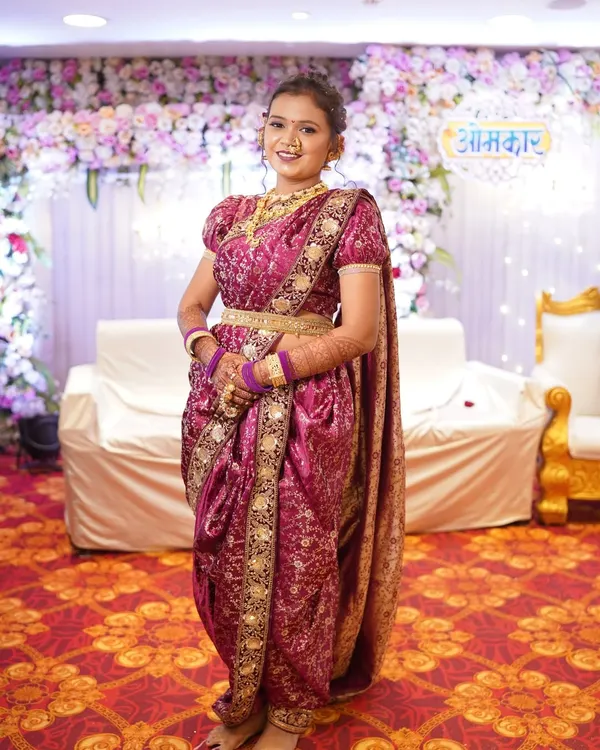 This is my classic magenta Peshwai bridal Nauvari look. It's a complete rental set, including the rich brocade saree with a puffed-sleeve blouse and all the traditional gold-finish jewellery, perfect for a bride's big day.