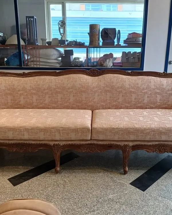 This classic sofa features a hand-carved wooden frame and is upholstered in a soft, textured pink fabric. It's a perfect example of how I blend traditional forms with contemporary textiles to create a timeless piece.