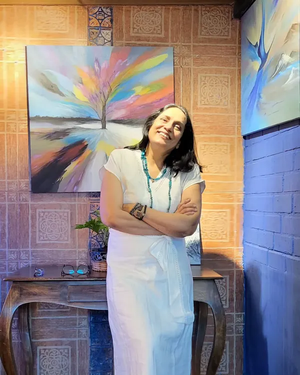 Artist Gurpreet Kaur, whose work blends oil and acrylics to create emotive landscapes, stands proudly with her art during her first solo exhibition at our gallery.