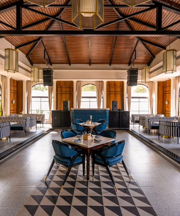 This perfectly symmetrical wide shot of Vamos Experience is designed to showcase the grandeur and meticulous design of the main dining hall. The leading lines in the flooring guide the eye, emphasizing the scale and elegance of the venue.