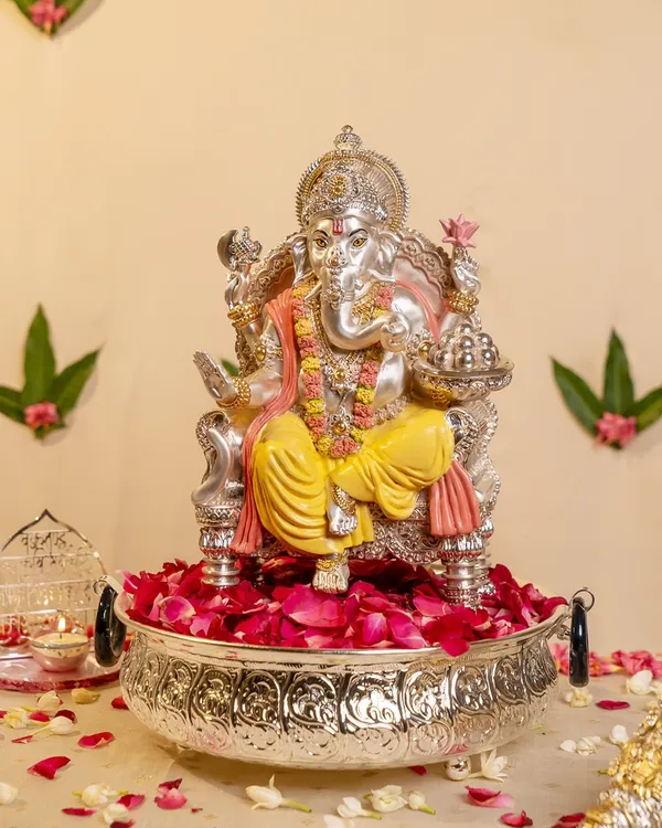 I designed this magnificent silver-plated Ganesha to be a centerpiece of devotion. Seated in a large urli bowl filled with fresh rose petals, this idol captures the grandeur and grace of the deity, perfect for welcoming blessings into your home.
