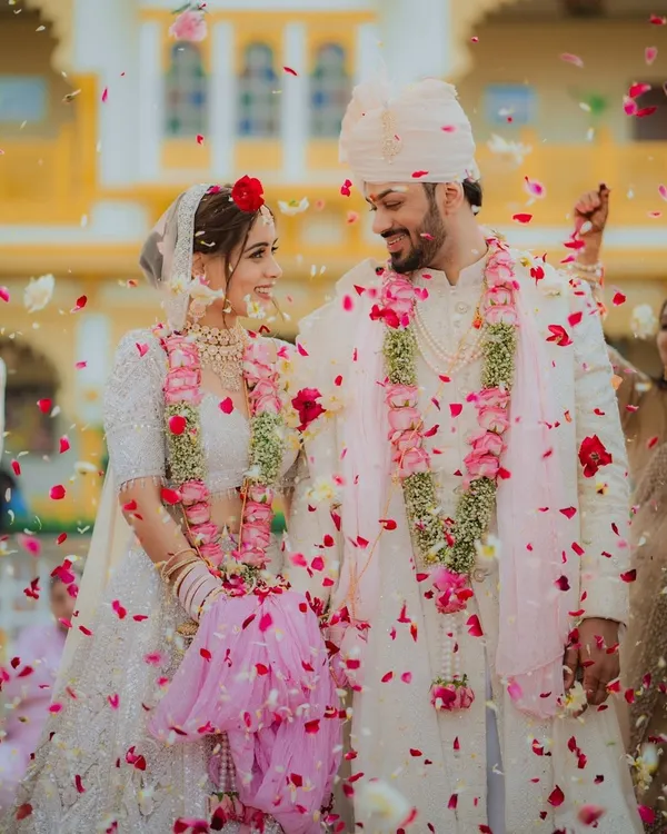 A candid moment of pure joy as the couple is showered with rose petals after their ceremony. We live for these unscripted celebrations that truly capture the spirit of a wedding day.