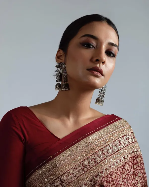 A powerful, royal inspired look from a professional photoshoot. It features dramatic smokey eyes, a flawless matte base, and a sleek low bun to create a regal and striking image.