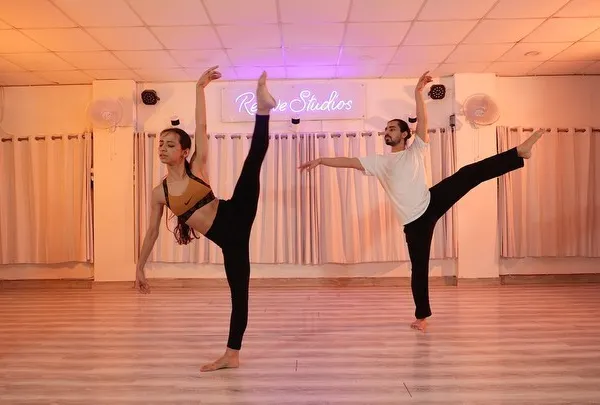 Dancers hold a challenging extension during a contemporary workshop. These sessions focus on building technique, strength, and flexibility in a collaborative environment.
