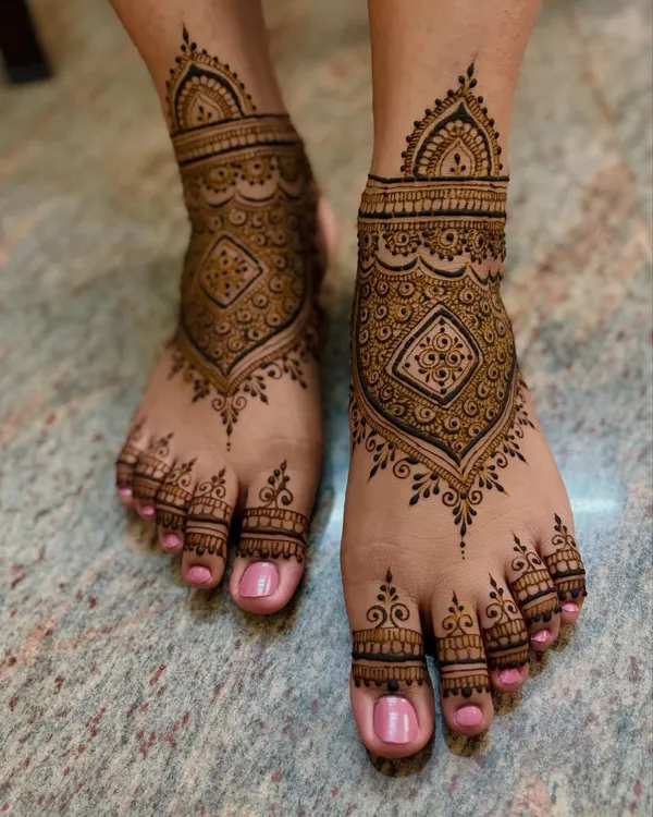 A stunning bridal feet mehendi for Vishnupriya, with a central geometric pattern and full coverage over the toes and ankle.