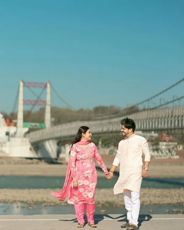 A simple, heartfelt moment of a couple in traditional attire walking hand-in-hand, with the iconic Ram Jhula bridge of Rishikesh in the background. It’s these quiet, authentic scenes that I love to capture.
