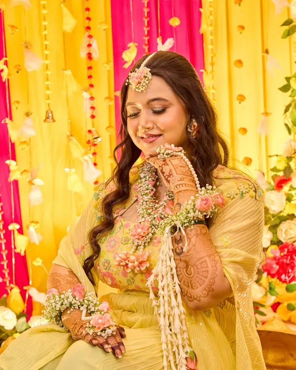 A serene portrait of the bride adorned with floral jewelry during her Haldi ceremony. I capture these quiet moments of beauty amidst the joyful chaos of the event.